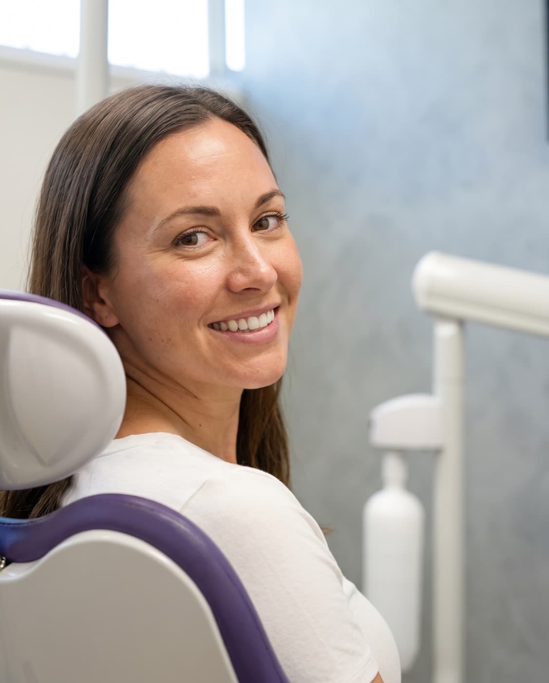 A patient smiling in the chair at Ash Dental Studio